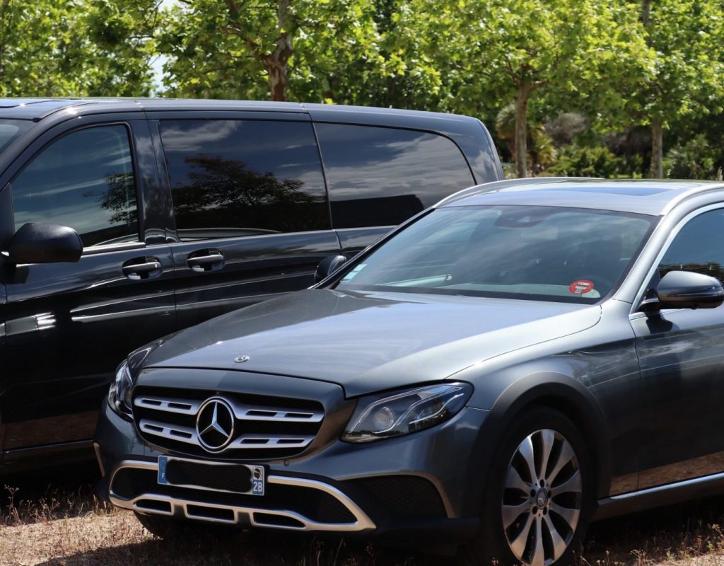 Photo d'une Mercedes Classe A grise au premier plan et un van noir Mercedes en arrière plan.